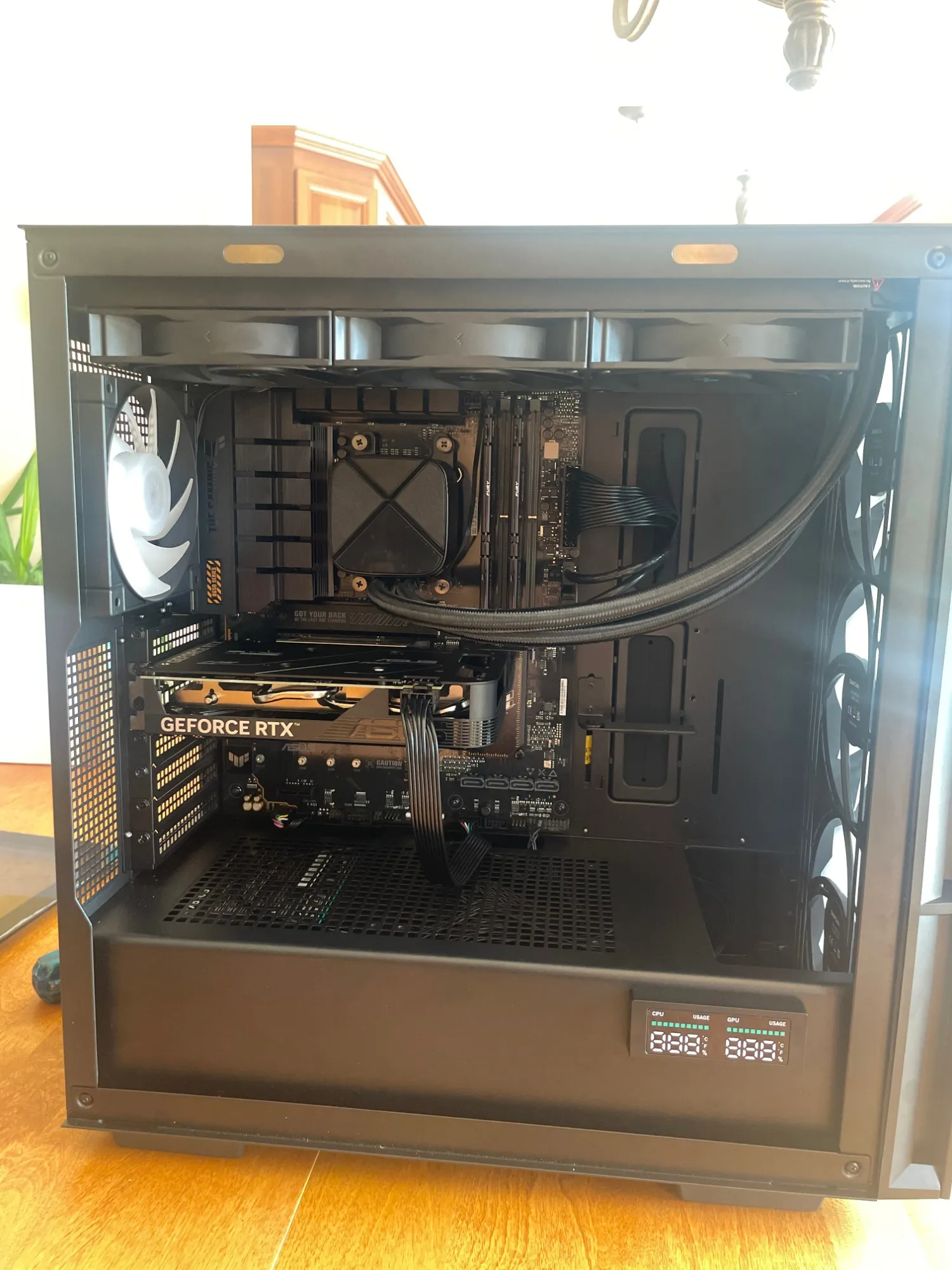 Ordinateur sur mesure monté par Info Dorais : boîtier noir avec carte graphique GeForce RTX, refroidissement liquide et affichage de température CPU/GPU.